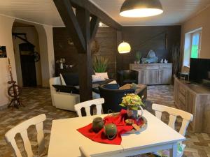 a living room with a table and chairs and a kitchen at Inas Spreewaldstube in Vetschau