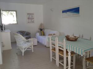 sala de estar con mesa, sillas y cama en Deliziosa Villa 150 metri dal mare, en Quartu SantʼElena