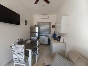 a small kitchen with a table and a refrigerator at Hacienda Gallardos 104-2 in San Carlos