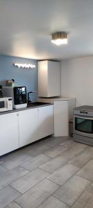 a kitchen with white cabinets and a microwave at HOME HOSE in Monistrol-sur-Loire