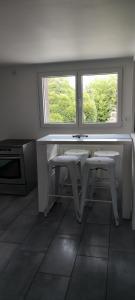 a kitchen with two windows and a table and two stools at HOME HOSE in Monistrol-sur-Loire
