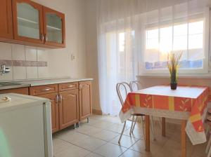 cocina con mesa, sillas y ventana en Holiday Vendégház, en Eger