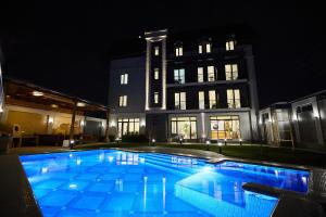 una piscina por la noche frente a un edificio en OLD TASHKENT Hotel & Spa en Tashkent