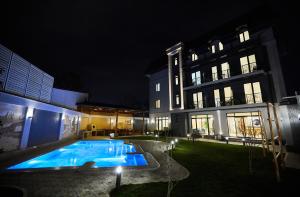 a swimming pool in the yard of a building at night at OLD TASHKENT Hotel & Spa in Tashkent