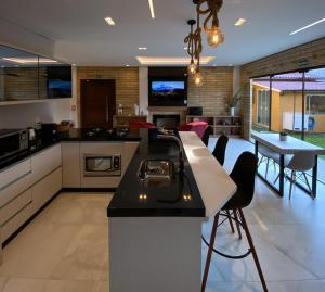 a large kitchen with a island and a dining room at Manaca House in Praia Grande