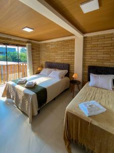 una camera con due letti e una grande finestra di Manaca House a Praia Grande