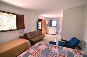 um quarto com uma cama, um sofá e uma cadeira em Refúgio Serra Negra - PE em Bezerros