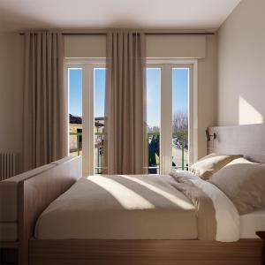 um quarto com uma cama grande e uma janela em La Dama del Porto em Laveno-Mombello