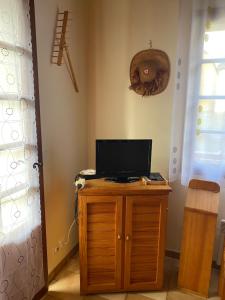 ein Zimmer mit einem Holzschrank mit einem TV darauf in der Unterkunft Chalet "Le Mayouret" - STUDIO N°4 - chemin des écureuils in Cauterets
