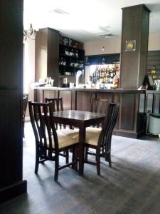stół i krzesła w kuchni z barem w obiekcie Pensiunea Clasic w mieście Curtea de Argeş