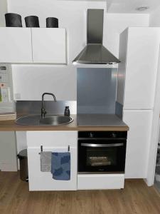a small kitchen with a sink and a stove at Vernon : La Marinière in Vernon