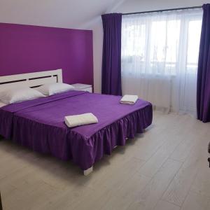 a bedroom with a purple bed with two towels on it at Andrhouse in Verkhovyna