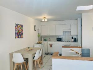 - une cuisine avec des placards blancs, une table et des chaises dans l'établissement Casa Rosa, à Rovio