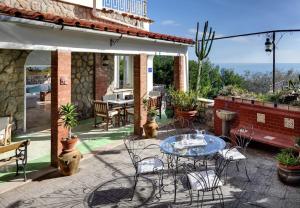 a patio with a table and chairs on a patio at Morso di luna in Nerano