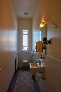 La salle de bains est pourvue d'un lavabo, de toilettes et d'un miroir. dans l'établissement Reykjavik Downtown Guesthouse, à Reykjavik
