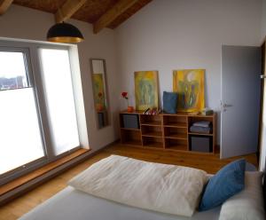 ein Wohnzimmer mit einem Bett und einigen Fenstern in der Unterkunft a.SIEBEN in Wittmund