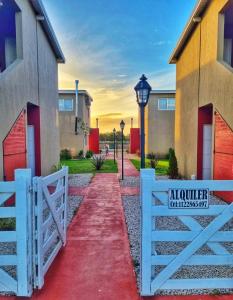 una recinzione bianca e un sentiero rosso davanti a una casa di APART ANTARES a Dolores