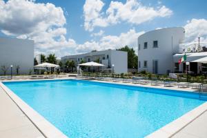 a pool at a hotel with chairs and umbrellas at Medea Beach Resort - Cultural Stay near Amalfi Coast & Paestum in Paestum +51 photos