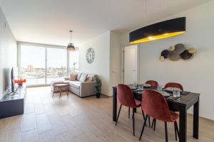a living room with a table and chairs and a couch at Brand New Apartment with Ocean & Volcano Views in Las Palmas de Gran Canaria