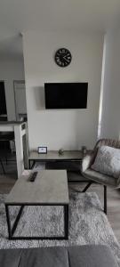 uma sala de estar com um sofá e uma televisão na parede em Perfect Place 33 em Varaždin