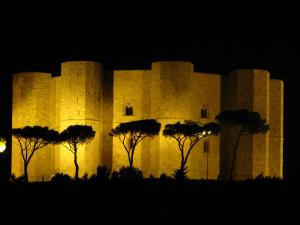 ein beleuchtetes Gebäude mit Bäumen davor in der Unterkunft B&B Tramonto d'Oro in Castel del Monte