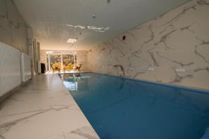 a large swimming pool with a marble wall at Villa Sarajevo in Vareš