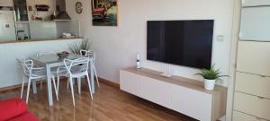 ein Wohnzimmer mit Fernseher und Tisch und Stühlen in der Unterkunft Mirador al mar in Bellreguart