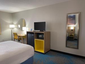 a hotel room with a bed and a television at Days Inn by Wyndham Colby in Colby