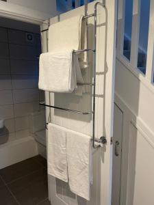 uma casa de banho com toalhas brancas penduradas num toalheiro em Welcome properties - Self Check-In whole apartment em Swindon