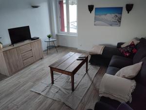 a living room with a couch and a coffee table at Grand Duplex, 6 personnes in Besse-et-Saint-Anastaise