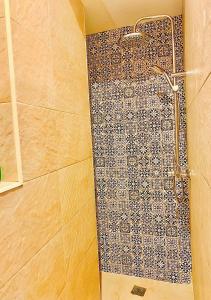 グラナダにあるLa Casa Rota de Granadaのタイル張りの壁のバスルーム(シャワー付)