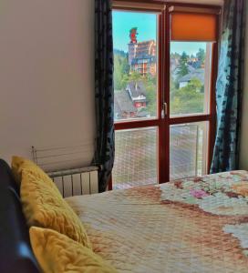 a bedroom with a bed and a window with a view at APARTMAN SNOW Vlašić in Vlasic