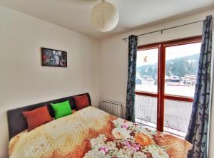 a bedroom with a bed with a large window at APARTMAN SNOW Vlašić in Vlasic