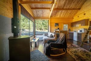 a living room with a stove in a house at Wood Cabin by the River - for Nature Lovers in Vitina