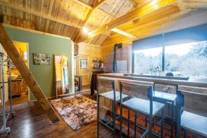 a room with a kitchen and a staircase in a house at Wood Cabin by the River - for Nature Lovers in Vytina