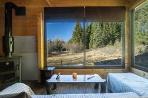 a room with a large window with a table in it at Wood Cabin by the River - for Nature Lovers in Vytina