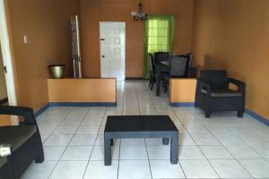 una sala de estar con sillas y mesa y una habitación con en Unity Villa one bedroom apartment with, cable, park wifi,near beach, en Montego Bay