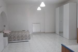 una grande camera bianca con un letto e un corridoio di Appartamento con incantevole panorama: Chieti alta a Chieti