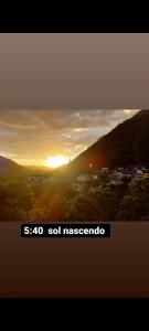 zdjęcie zachodzącego słońca nad miastem w obiekcie Cobertura das Montanhas w mieście Domingos Martins