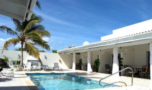 een villa met een zwembad en een resort bij Yoyita Suites Aruba Villa in Palm-Eagle Beach