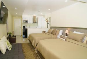 Habitación de hotel con 2 camas y cocina en Yoyita Suites Aruba Villa en Palm-Eagle Beach