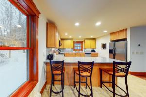 a kitchen with two bar stools and a counter at Misty Maple in Plymouth