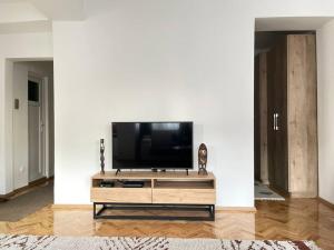 a living room with a flat screen tv on a white wall at City Center Studio Apartment in Gjakove