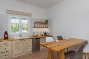 a kitchen with a wooden table and a wooden counter top at Vitalis Residences - Rural Living in Péran Triovasálos +15 photos