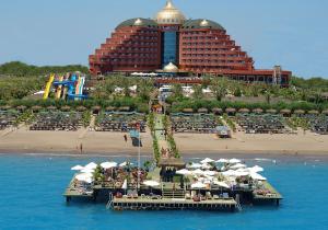 a resort with a beach and a roller coaster at Delphin Palace Hotel in Lara