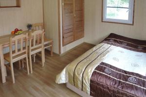a bedroom with a table and a bed and a dining room at Bungalows in Wrzosowo The Bird s Cage for 4 persons in Wrzosowo