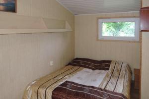 a bed in a small room with a window at Bungalows in Wrzosowo The Bird s Cage for 4 persons in Wrzosowo