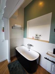 ein Badezimmer mit einer Badewanne und einem Waschbecken in der Unterkunft L'ILE DES PREVOTS in Crosne