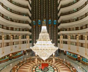 a large chandelier hangs from the ceiling of a large building at Delphin Palace Hotel in Lara