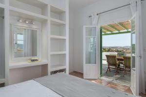 a bedroom with a bed and a dining room with a table at Vitalis Residences - Rural Living in Péran Triovasálos
